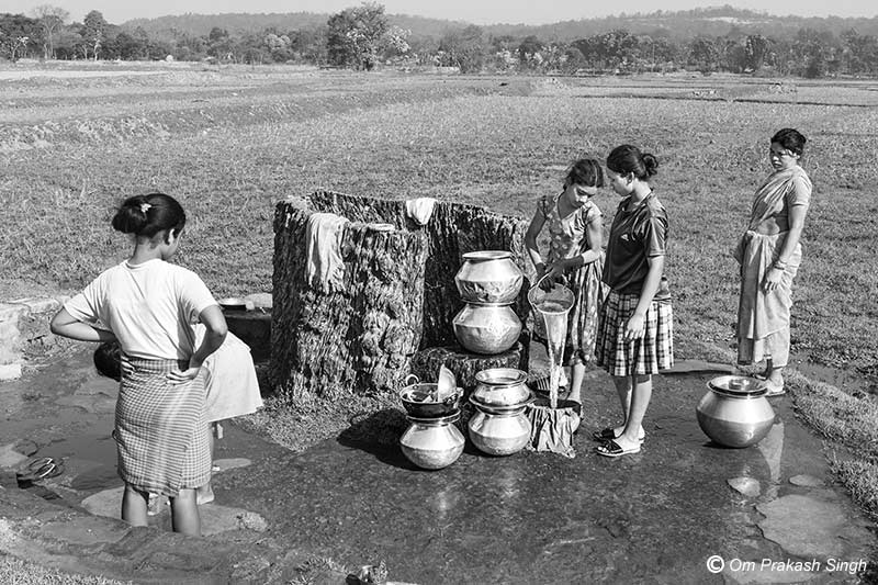 Drinking water procurement from a traditional spring-based wooden-lined source in Khunti district, Jharkhand, India